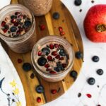 3 mason jars filled with pomegranate-blueberry overnight oats.