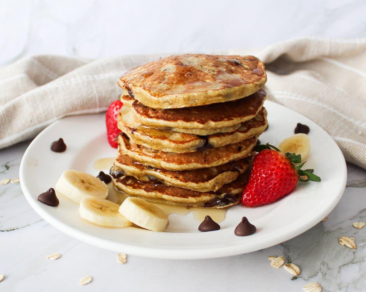 Stack of fluffy chocolate chip pancakes on a plate.